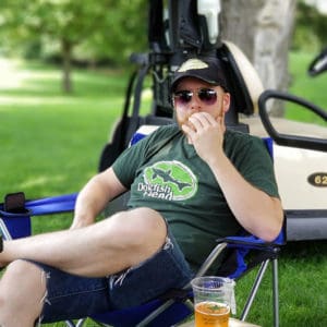 Man sitting on a chair with a cup of beer at the Hero Dogs event